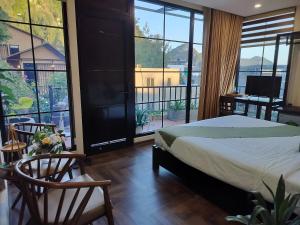 a bedroom with a bed and a balcony with windows at Catba Garden Camellia in Cat Ba +68 photos