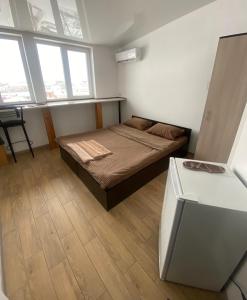a bedroom with a bed in a room with windows at Студія в центрі міста , 7 поверх без ліфту in Ivano-Frankivsk