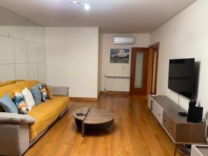 a living room with a couch and a flat screen tv at House Infantado Loures in Loures