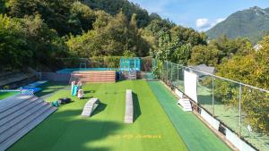 a tennis court with benches on a green field at Chuncheon Dogandstay in Chuncheon