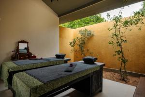 a room with two beds and a mirror on the wall at Rekawa Wellness Resort in Tangalle