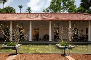 a house with a pond in front of it at Rekawa Wellness Resort in Tangalle
