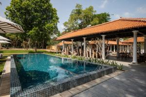 a swimming pool in front of a house with a gazebo at Rekawa Wellness Resort in Tangalle