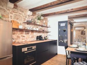 a kitchen with a counter and a stone wall at Molo selo area in Stari Grad