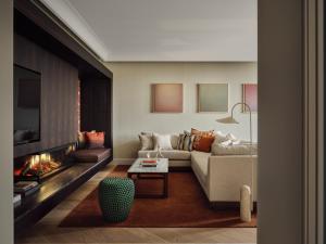 a living room with a couch and a fireplace at The Florentin by Althoff Collection in Frankfurt