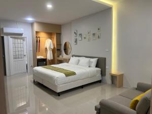 a bedroom with a bed and a couch and a mirror at เพาะสุข กู๊ดดรีม in Ban Wang Hu Kwang