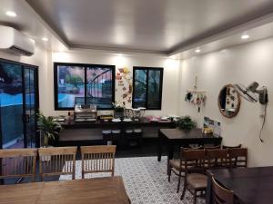 a dining room with a table and chairs and a desk at Catba Garden Camellia in Cat Ba