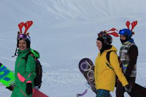 three people are standing in the snow with snowboards at Apartments in New Gudauri in Gudauri