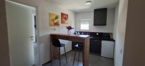 a small kitchen with a counter and stools in it at Gold Apartmani Kozarac in Kozarac