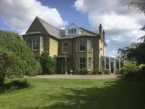 een groot bakstenen huis met een grote tuin bij Beech View Cottage in Downham Market