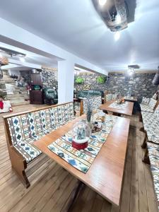 a dining room with a long table and benches at Къща за гости ЕМА in Vetren Dol