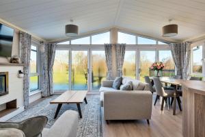 a living room with a couch and a table at Finest Retreats - Pembroke Luxury Lodge in Bourn