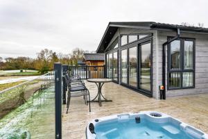 a house with a hot tub on a deck at Finest Retreats - Pembroke Luxury Lodge in Bourn