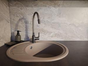 a sink with a faucet on top of a counter at Manere commoda in Šiauliai +39 photos
