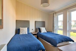 two beds sitting in a room with a window at Finest Retreats - Pembroke Luxury Lodge in Bourn +18 photos