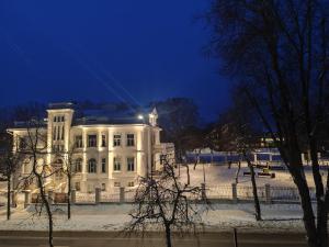 a white building with lights on it at night at Manere commoda in Šiauliai