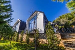 a house with glass windows on a stone wall at Muraga Villas by PikHost in Tirana