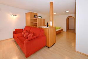 a living room with a red couch and a bedroom at Ferienhof Steurer in Balderschwang