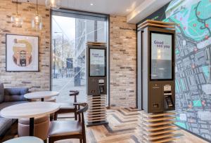a restaurant with tables and chairs and a brick wall at hub London - Marylebone in London