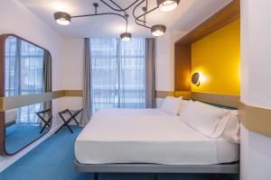 a bedroom with a white bed and a yellow wall at Soho Boutique Granada in Granada +47 photos