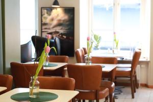 a restaurant with tables and chairs with flowers on them at Hotell Aston in Karlskrona