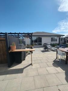 a patio with a wooden table and a pergola at Brightwater Beauty in Brightwater