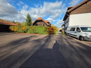 a shadow of a man standing in the road next to a van at Ferienhaus John in Saarwellingen