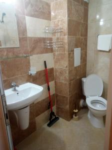 een badkamer met een toilet, een wastafel en een dweil bij Apartments Vesi and Gery in Pomorie