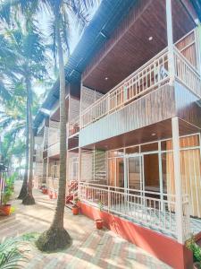 a building with palm trees in front of it at The Racha Agonda in Agonda