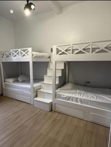 two white bunk beds in a room with wooden floors at Cecilia Hostel in Cairo +96 photos