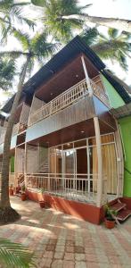 a building with a palm tree in front of it at The Racha Agonda in Agonda +25 photos