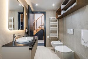 a bathroom with two sinks and a toilet and a mirror at Muraga Villas by PikHost in Tirana +171 photos