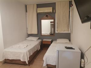 two beds in a room with a mirror and a mirror at denge pansiyon in Datca