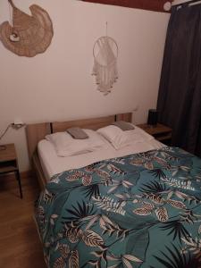 a bedroom with a bed with a green and blue blanket at Gites panoramique in Sainte-Livrade-sur-Lot