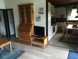 a living room with a tv on a wooden dresser at Haus H7 in Großwürden
