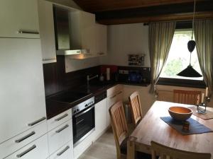 a kitchen with a table and a sink and a stove at Haus H7 in Großwürden +5 photos