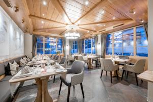 a restaurant with tables and chairs and windows at Edelweiss Swiss Quality Hotel in Sils Maria