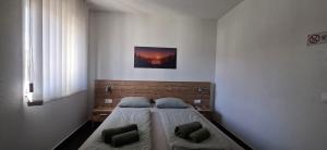 a bedroom with a bed with two pillows on it at Gold Apartmani Kozarac in Kozarac
