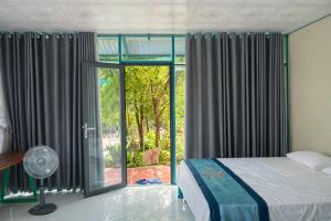 a bedroom with a bed and a large window at Đức Lưu Quang Hotel Bình Thuận in Tuy Phong +79 photos