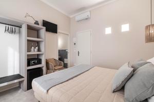 a white bedroom with a bed and a television at Le Valli in Pellestrina