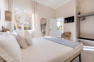 a white bedroom with a large bed with white pillows at Le Valli in Pellestrina