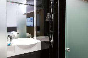 a bathroom with a sink, mirror and bathtub at The Z Hotel City in London