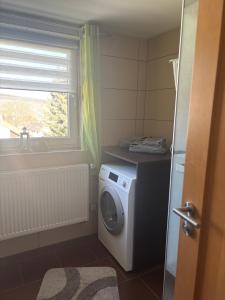 a laundry room with a washing machine and a window at Ferienwohnung Schaller in Berg