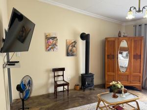 a living room with a wood stove and a tv at De Trout Huis Guesthouse in Dullstroom