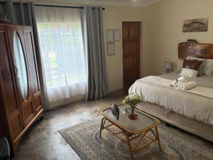 a bedroom with a bed and a table with a coffee table at De Trout Huis Guesthouse in Dullstroom