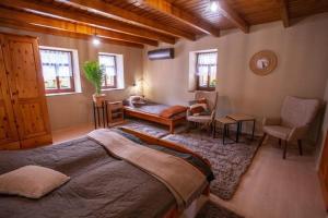 a bedroom with a large bed and a desk and chair at Nagyon Vadon vendégház in Háromhuta