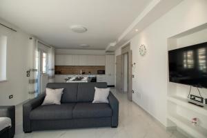 a living room with a couch and a kitchen at Alessia Living in San Michele allʼAdige