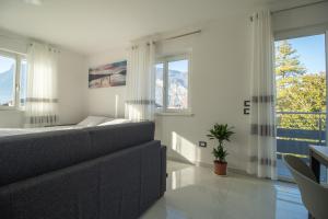 a living room with a couch and large windows at Alessia Living in San Michele allʼAdige