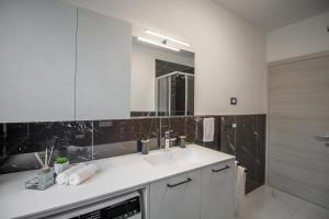 a white bathroom with a sink and a mirror at Alessia Living in San Michele allʼAdige +47 photos