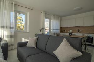 a living room with a couch and a kitchen at Alessia Living in San Michele allʼAdige